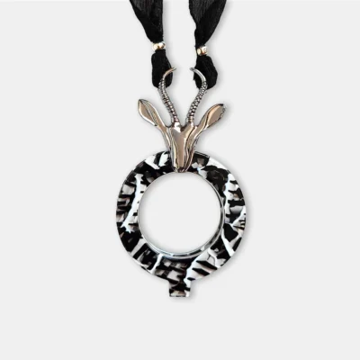 Lupa de lectura colgante Gacela blanco y negro de la colección Savannah con figura bañada en plata y collar de seda natural